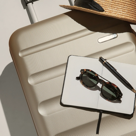 Valise avec lunettes de soleil et carnet de notes